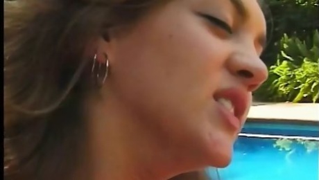 Sexy brunette teens lick each other and play with toys next to the pool